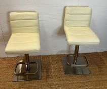 Two faux cream bar stools with chrome bases