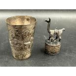 Two silver curios marked 925, a camel on plinth and a beaker