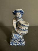 A Delft blue and white salt of a monkey, dresses as a maid holding a bucket Condition Report some