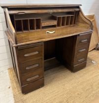 An Edwardian oak roll top desk comprising of six drawers, storage compartments and original key (