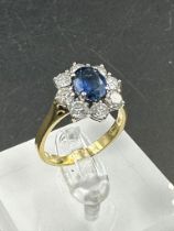 A sapphire and diamond cluster ring on an 18ct (750) shank.