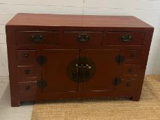 A red Lacquer chest sideboard with three drawers across the top and double doors to centre (H90cm