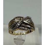 A 9ct yellow gold and diamond cross over ring with baguette style setting Size L