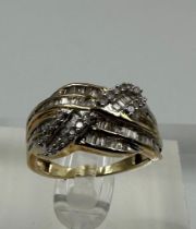 A 9ct yellow gold and diamond cross over ring with baguette style setting Size L