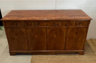 A yew sideboard with double doors opening to shelves flanked by cupboards and drawers above (H80cm