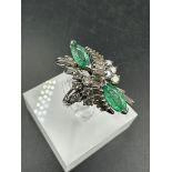 An emerald and diamond ring, designed a s a vertically set elongated cluster with two marquise cut