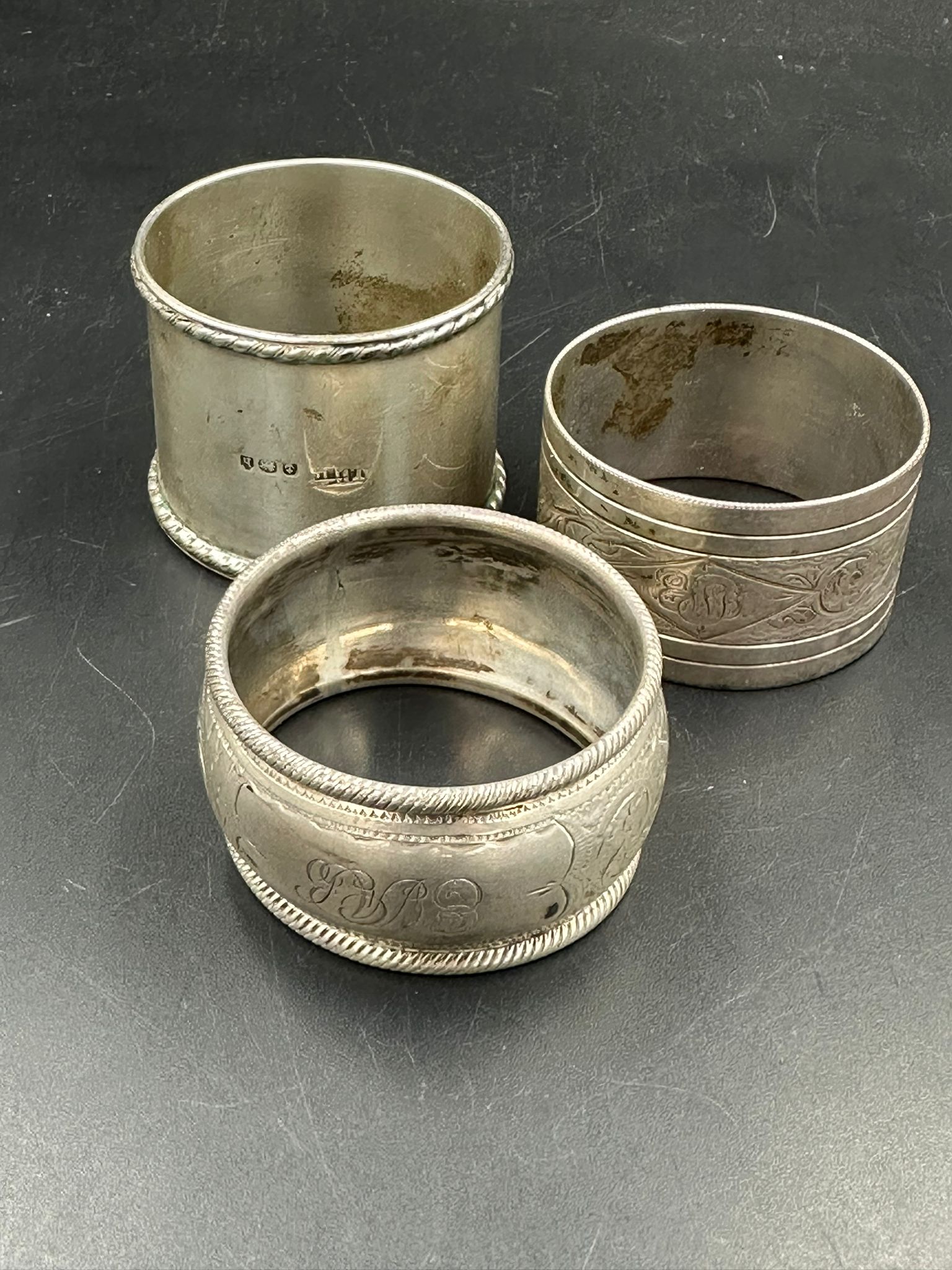 A selection of three silver hallmarked napkin rings, various hallmarks and makers. (Approximate