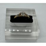 An 18ct and platinum set diamond ring with central stone and shoulders Size M