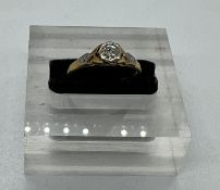 An 18ct and platinum set diamond ring with central stone and shoulders Size M