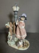 A large boxed Lladro figure of a young girl and her cat by a lamp post Condition Report Good