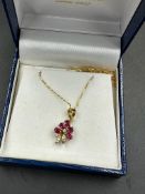 An 18ct, marked 750, chain with diamond and ruby floral themed pendant, approximate total weight 2.