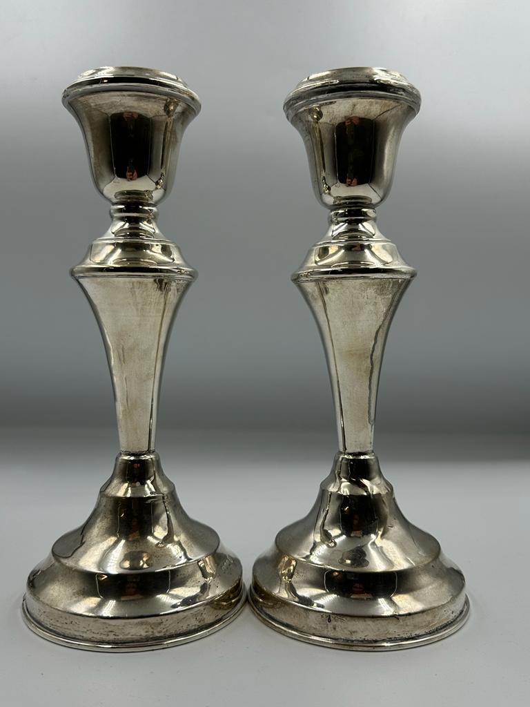 A Pair of filled silver candlesticks by hallmarked for London 1922, makers marks JE