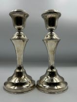 A Pair of filled silver candlesticks by hallmarked for London 1922, makers marks JE