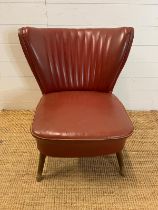 A cherry red cocktail chair with fluted back and teak legs