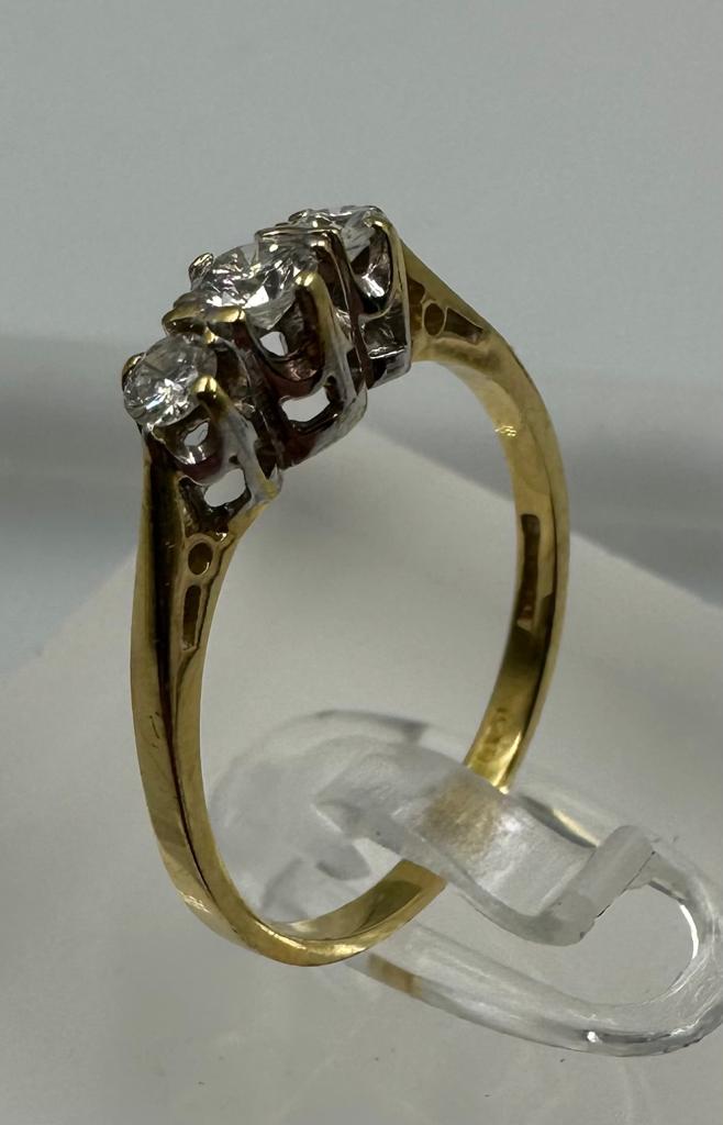 An 18ct three stone diamond ring, approximate size M1/2