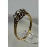 An 18ct three stone diamond ring, approximate size M1/2