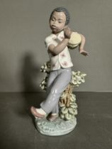A Lladro figure of a young boy playing a drum