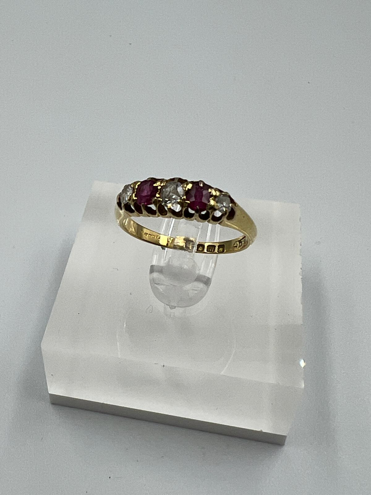 An 18ct yellow gold diamond and ruby ring, approximate size M