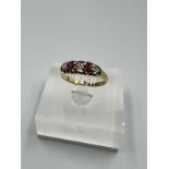 An 18ct yellow gold diamond and ruby ring, approximate size M