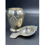 A Thai Sterling silver, embossed cup and tea strainer, approximate total weight 120g.