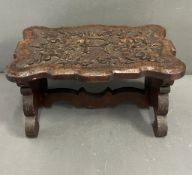 A carved oak low stool