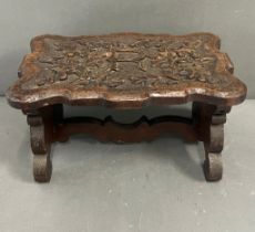 A carved oak low stool