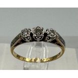 An 18ct and platinum three stone diamond ring with diamond shoulders, size N1/2