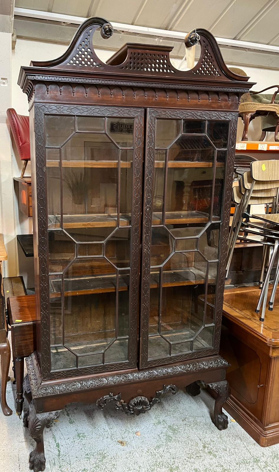 Georgian glazed library cabinet with scrolling cornice, carved framed glazed doors opening to pegged