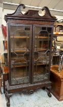 Georgian glazed library cabinet with scrolling cornice, carved framed glazed doors opening to pegged