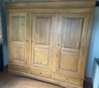 A large light oak triple door wardrobe with three drawers under. (Approx. H230cm W230cm D60cm)