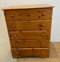 A pine effect chest of drawers (H110cm W83cm D44cm)