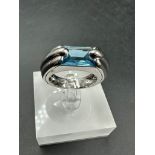 A single stone Audemars Piguet ring consisting of a rectangular mixed cut blue topaz stone (12.1mm x