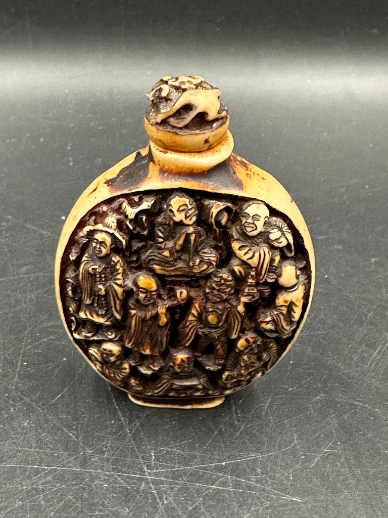 A Chinese hand carved resin snuff bottle depicting the Immortals