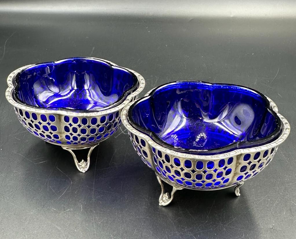 A pair of silver salts with pierced design and blue glass liners by Synyer & Beddoes, hallmarked for