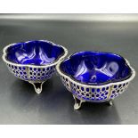 A pair of silver salts with pierced design and blue glass liners by Synyer & Beddoes, hallmarked for