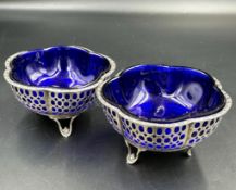 A pair of silver salts with pierced design and blue glass liners by Synyer & Beddoes, hallmarked for