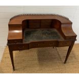 An Edwardian style Carlton house desk with brass galleried top, string inlay and tapering legs (