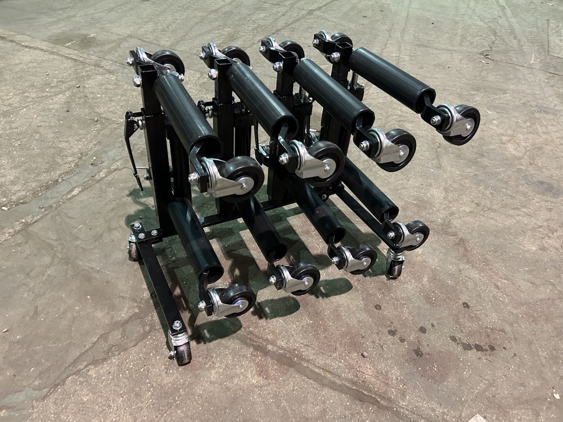 New and unissued set of 4 Heavy Duty Hydraulic Wheels Skates on storage stand