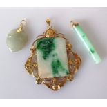 A Chinese oblong jade pendant with etched decoration in a pierced gold frame, stamped 14k