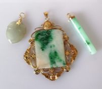 A Chinese oblong jade pendant with etched decoration in a pierced gold frame, stamped 14k