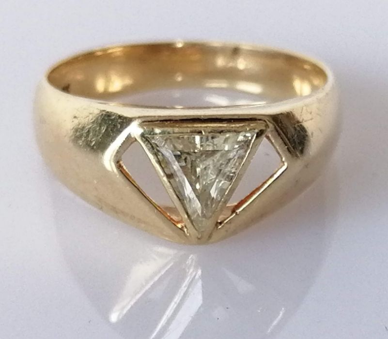 A trilliant-cut diamond ring in a rubover yellow gold setting on a tapering shank