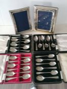 Four cased sets of silver spoons and two silver photo frames