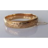 A ladies 9ct yellow gold hinged bangle with etched decoration, 60mm, hallmarked, 16.2g