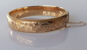 A ladies 9ct yellow gold hinged bangle with etched decoration, 60mm, hallmarked, 16.2g