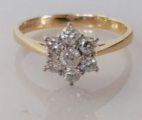 A diamond cluster ring on an 18ct gold setting, the central brilliant-cut diamond