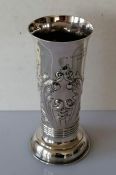 A late Victorian silver vase of cylindrical form with a flared rim, embossed floral decoration