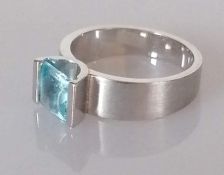 A single stone topaz ring, the square-cut topaz, semi-bezel set, stamped 18ct, size O, 8.33g