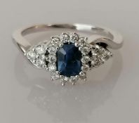 A blue sapphire and diamond cluster ring on an 18ct white gold claw setting