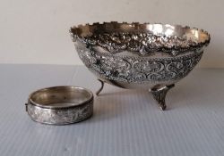 An Oriental circular bowl with embossed band on tripod feet, 8 h x 15.5 cm diameter, stamped silver