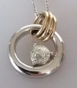 A diamond pendant designed as an open circle, set with a fancy-cut, domed diamond